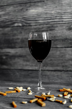 Glass of red wine with crackers on a dark wooden background.の写真素材
