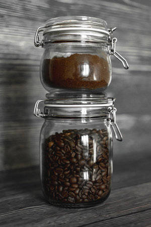 Roasted coffee beans in a cup with ground coffee on wooden backgroundの写真素材
