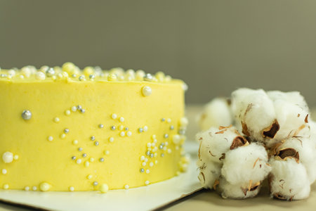 Birthday cake decorated with white pearls and cotton flowers. Selective focus.の写真素材