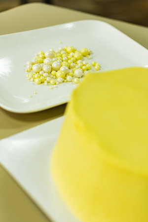 Yellow cake with pearls on a white plate. Selective focus.の写真素材