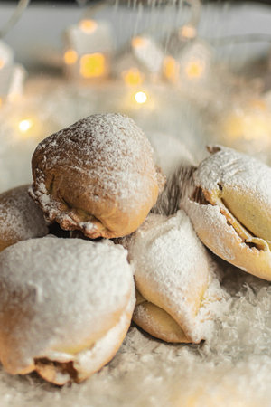 biscuits sprinkled with powdered sugar on a white background with Christmas lightsの写真素材