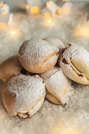 biscuits sprinkled with powdered sugar on a background of Christmas lightsの写真素材