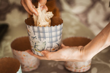 Close-up of a woman's hands holding a cupcake.
