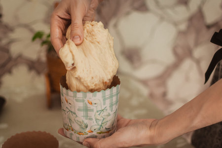Female hands hold a cupcake in the form of a muffin.