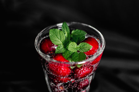 Strawberry mojito with mint in glass on black backgroundの写真素材