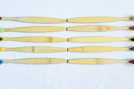Wooden toothbrushes on a white tablecloth, top viewの写真素材