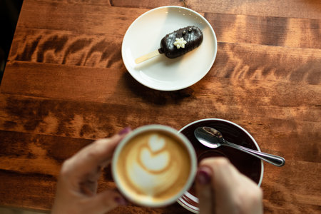 Coffee cup and chocolate cake on wooden table in coffee shopの写真素材