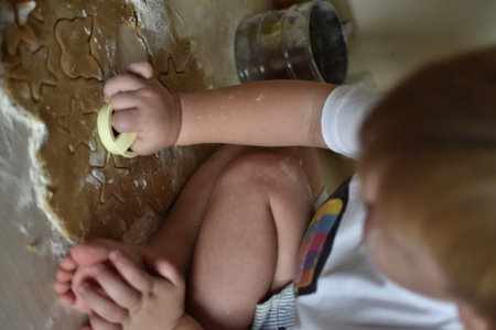 Little baby boy baking gingerbread cookies in the kitchen at home.の写真素材
