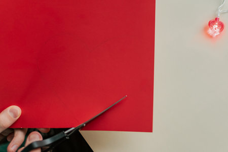 Close up of woman cutting red envelope with scissors on white background.の写真素材