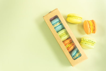 Colorful macaroons in paper box on pastel green backgroundの写真素材