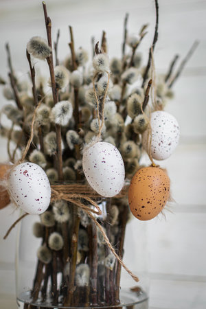 Easter eggs and willow branches on a white wooden background.の写真素材