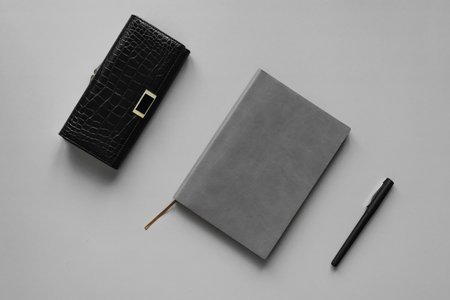 Black leather notebook and pen on a white background. Top view.の写真素材