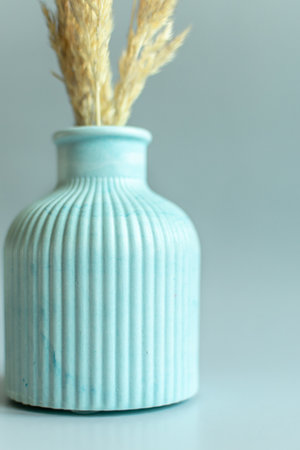 Vase with dry grass on gray background. Selective focus.の写真素材