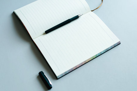 Notebook and pen on a white background with space for text.の写真素材