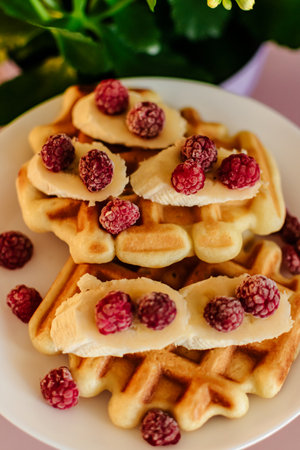 waffles with raspberries on a white plate close-upの写真素材