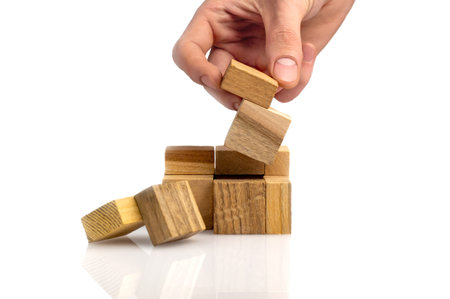 man's hand adds the last missing piece of the wooden puzzle in place. Business success concept....
