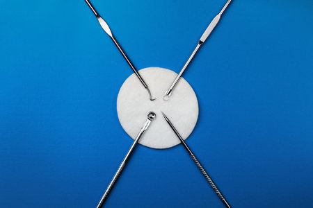 set of cosmetic products for manual cleaning of the face on a blue background with a cotton discs....