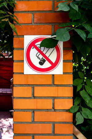 No smoking sign on a brick wall in a public place. Concept of banning smoking in public places, dangers and addictions of smoking. Vertical photoの写真素材