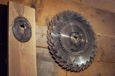 set of circular saw blades hangs on a wooden wall in the carpentry workshop. circular saw. old...
