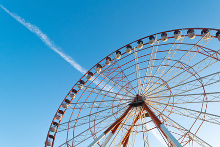 Ferris wheel against the blue sky. Amusements and attractions. Recreation and entertainment.