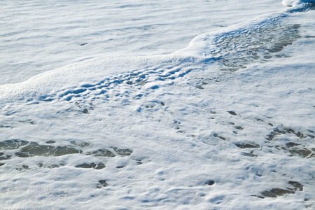 Sea foam on the beach. Sea coast. Marine natural background. Seascape.
