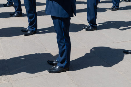 Men in identical blue suits stand in a linear formation.