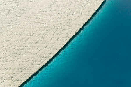 Sandy shore and water, view from above. Holidays at sea. Summer background. Summer landscape.