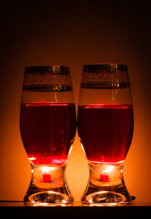 Two wineglasses with two candels behindの写真素材