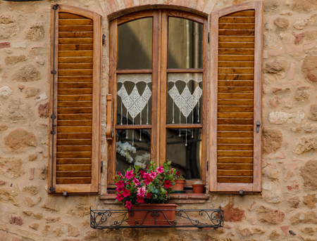 The window with flowers and wooden shutters. Pienza, Italyの写真素材