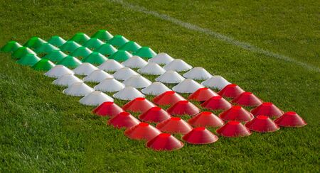 Cone marker for football training in color of italian flag on the green fieldの写真素材