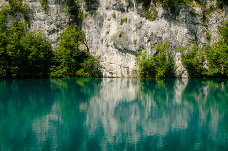 Reflection of rock in the blue Plitvice Lake, Croatiaの写真素材