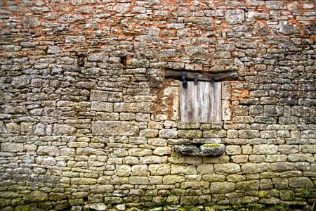 Old yellow stone wall with close window and wood beam, village in France (3)の写真素材