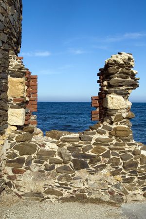 The destroyed window of an old tower with a kind on the sea, Stintino, Sardinia, Italyの写真素材