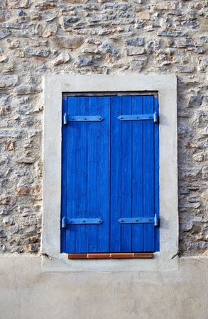 Window dark blue shutter in he stone wall, small town in Franceの写真素材