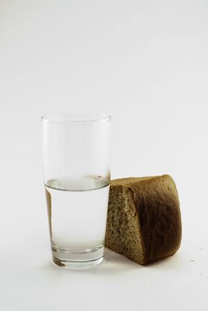 glass of water and bread isolated against white backgroundの写真素材