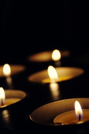 Vertical dark background with many lit candlesの写真素材