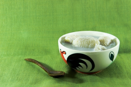 Banana in coconut milk with wood spoon on green の写真素材