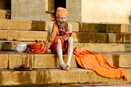 VARANASI, INDIA - OCT. 23 : A hermit sit and pray on the ghat at Ganga riverside in the morning on October 23, 2014 in Varanasi, Uttar Pradesh, India.Ganga river is holy river for Hindu peopleのeditorial素材