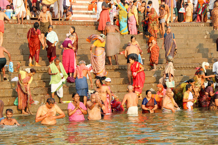 VARANASI, INDIA - OCTOBER 23: Hindu people take a bath in the river ganges in the morning on October 23, 2014 
at ghat in Varanasi, Uttar Pradesh, India.のeditorial素材