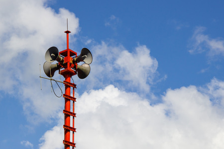 Loudspeaker on red pole in blue skyの写真素材