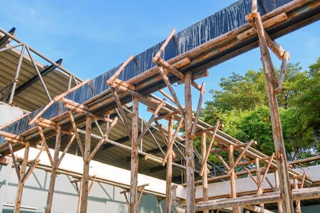 Bamboo prop beam, house under construction on blue skyの写真素材