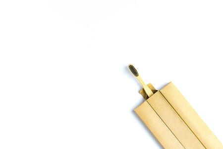 Bamboo toothbrush with black bristles in a paper box on a white backgroundの写真素材