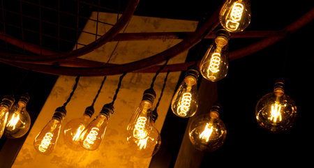 A classic Edison light bulb on dark ceiling.