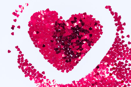 Bright-pink sparkles in the shape of a heart on a white background. Concept for Valentine's Day.