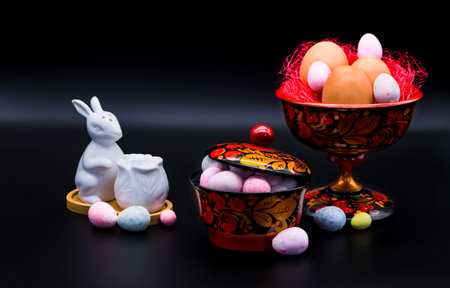 Brown eggs in a Khokhloma vase and small multi-colored eggs in a Khokhlama bowl and easter rabbit...