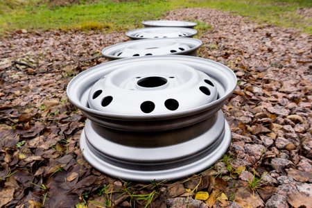 Metal stamped rims for passenger cars lie on the outdorの写真素材