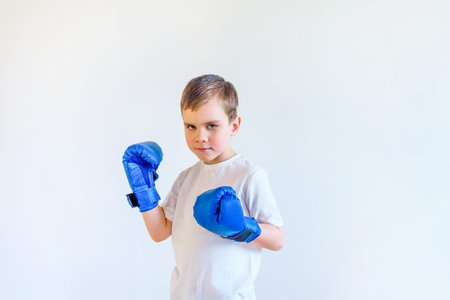 A boy in boxing gloves stands in a fighting stance. Sports and self-defense.の写真素材