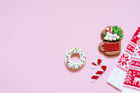 Donut, gingerbread and tea towel on pink background with copy space for your text, top view, flat...