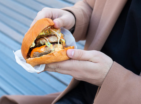 burger with 2 cutlets holding a manの写真素材