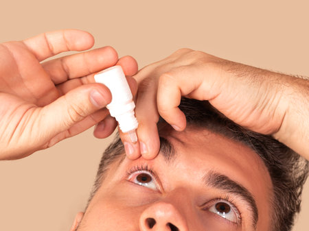 Young man uses eye drops for eye treatment. Redness, Dry Eyes, Allergy and Eye Itchingの写真素材